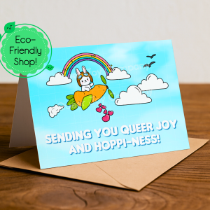 A cute kawaii bunny in a carrot airplane flies beneath a rainbow and clouds delivering hearts with a title saying Sending You Queer Joy and Hoppi-ness